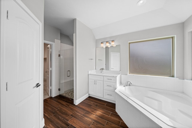 bathroom featuring vanity, lofted ceiling, separate shower and tub, and hardwood / wood-style floors