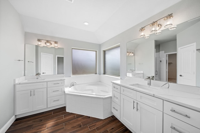 bathroom featuring vanity, shower with separate bathtub, wood-type flooring, and vaulted ceiling