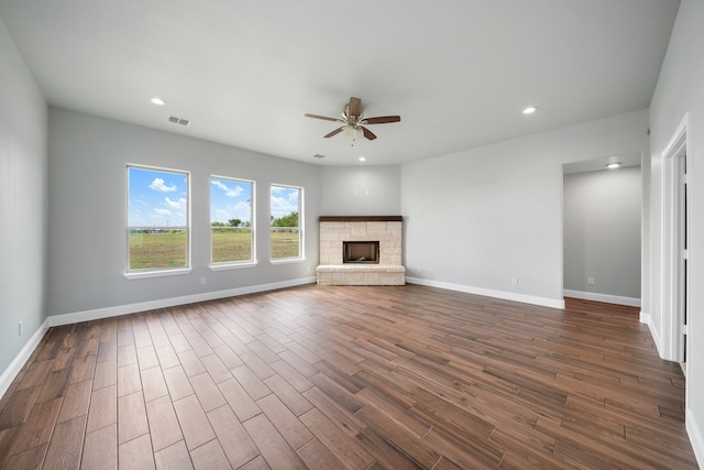 unfurnished living room with dark wood-type flooring, ceiling fan, and a fireplace