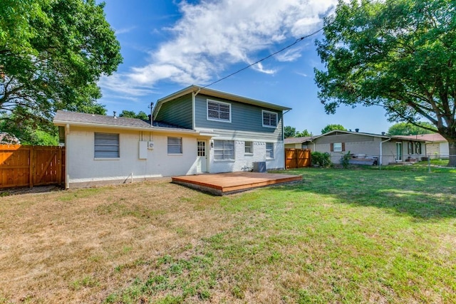 rear view of house featuring a lawn, a wooden deck, and central AC unit