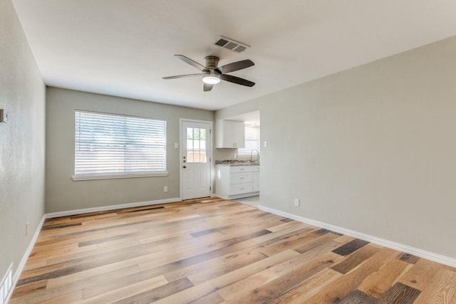 unfurnished living room with ceiling fan and light hardwood / wood-style flooring