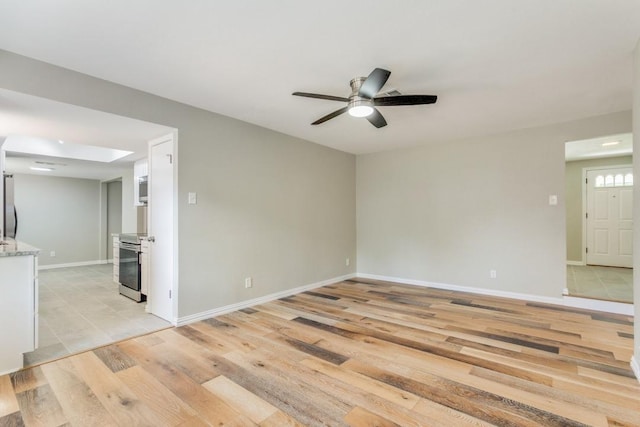 unfurnished room with light wood-type flooring, a skylight, and ceiling fan