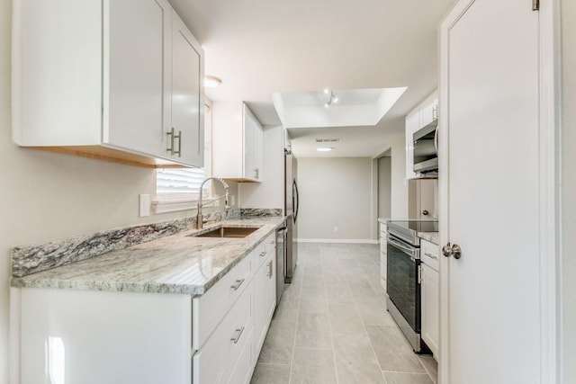 kitchen with white cabinetry, sink, stainless steel appliances, light stone counters, and light tile patterned floors