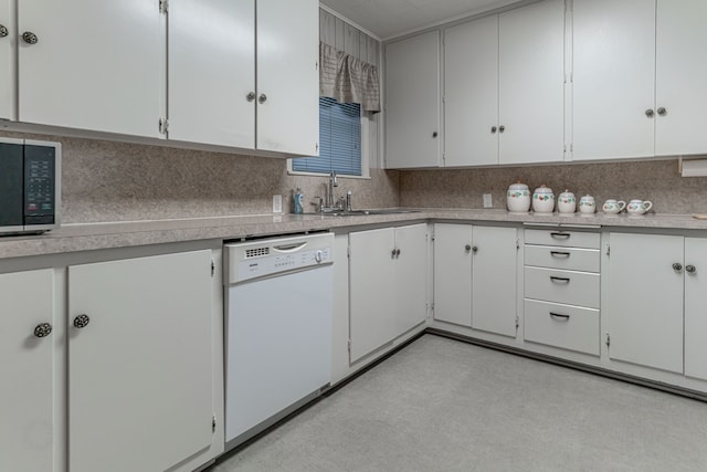 kitchen with sink, black microwave, white dishwasher, and white cabinetry