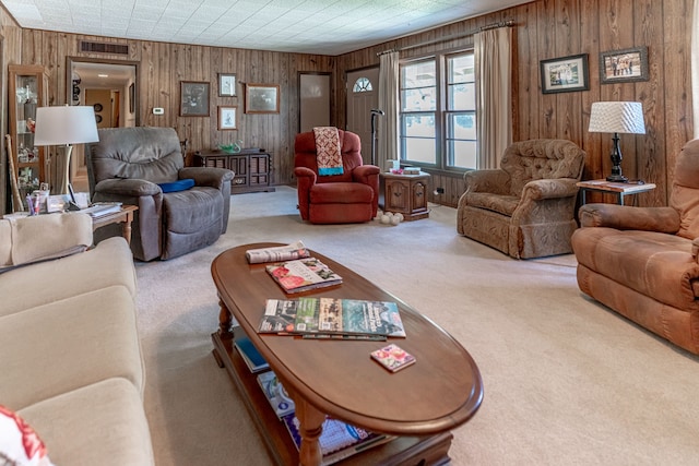 living room with wood walls and light colored carpet