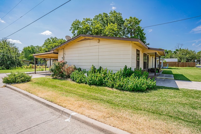 view of property exterior with a carport and a yard