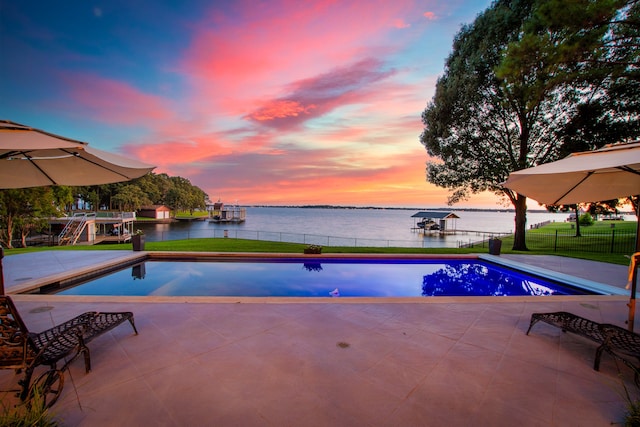 pool at dusk with a boat dock and a water view