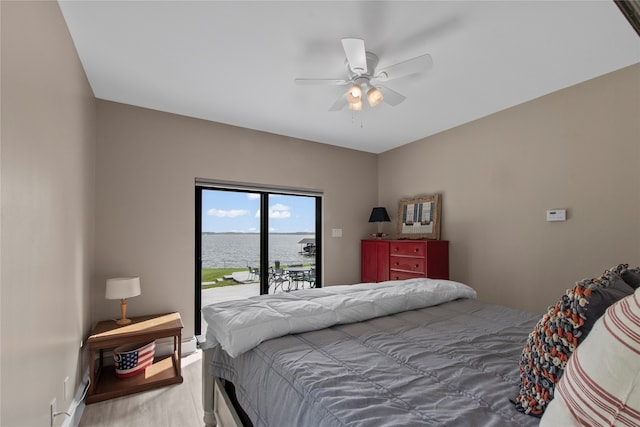 bedroom featuring ceiling fan, a water view, and access to outside