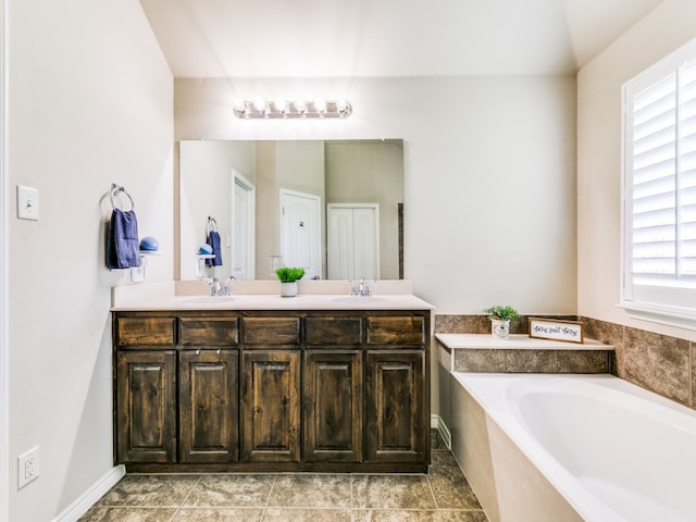 bathroom featuring tile patterned floors, double sink vanity, and a bath