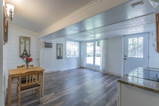 interior space with a wall mounted AC, lofted ceiling, and dark wood-type flooring