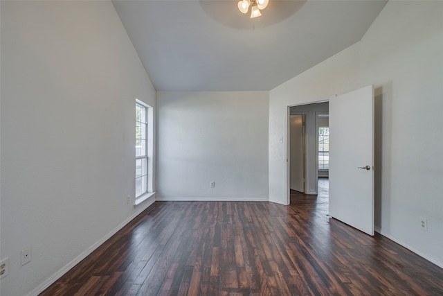 spare room featuring lofted ceiling, a healthy amount of sunlight, dark wood-type flooring, and ceiling fan