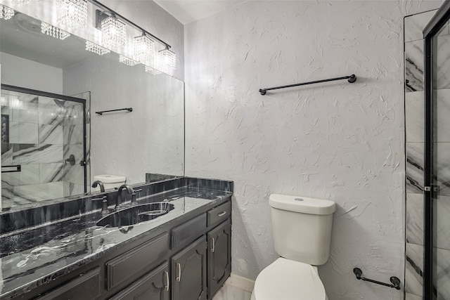 bathroom featuring toilet, a shower with shower door, and vanity