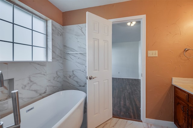 bathroom with vanity, hardwood / wood-style floors, and a bath