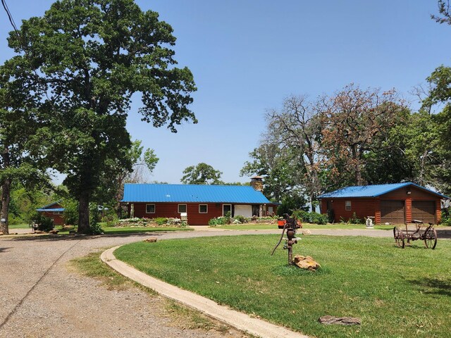 view of front of property featuring an outbuilding, a garage, and a front lawn