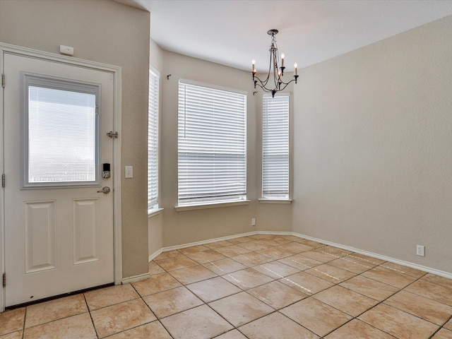 unfurnished dining area with a healthy amount of sunlight, a chandelier, and light tile patterned floors