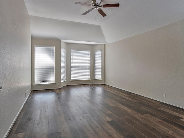 spare room with ceiling fan, vaulted ceiling, and dark hardwood / wood-style floors