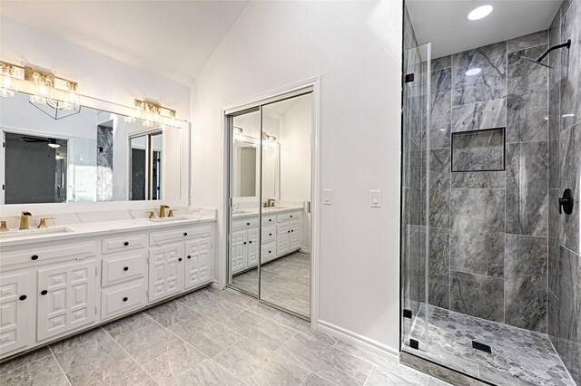 bathroom with vanity, lofted ceiling, tiled shower, and ceiling fan