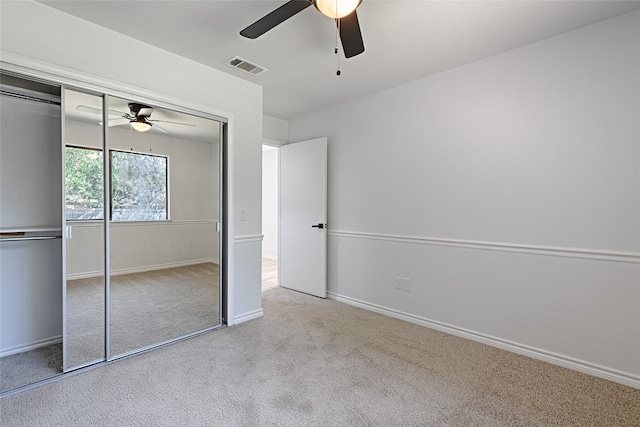 unfurnished bedroom featuring a closet, ceiling fan, and light colored carpet