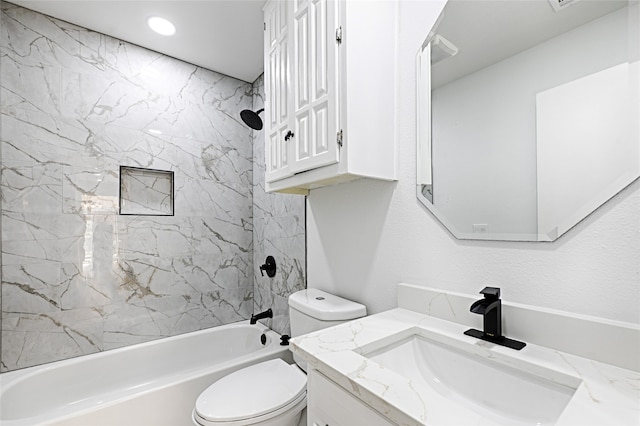 full bathroom featuring tiled shower / bath, vanity, and toilet