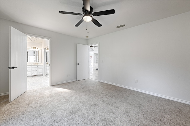 unfurnished bedroom featuring connected bathroom, light colored carpet, and ceiling fan