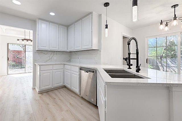 kitchen with stainless steel dishwasher, white cabinets, and kitchen peninsula