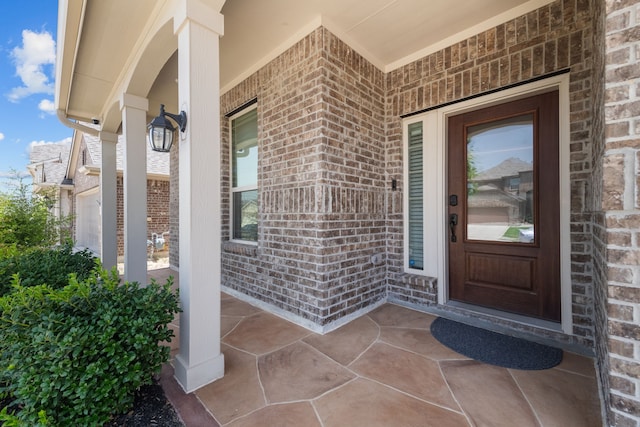 view of exterior entry with a garage and a porch