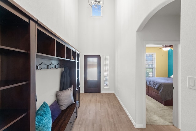 mudroom with light hardwood / wood-style floors, ceiling fan, and a high ceiling