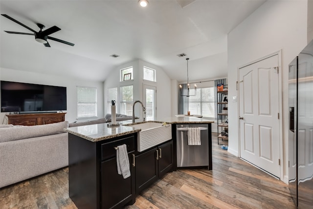 kitchen featuring lofted ceiling, light hardwood / wood-style flooring, a center island with sink, stainless steel appliances, and sink