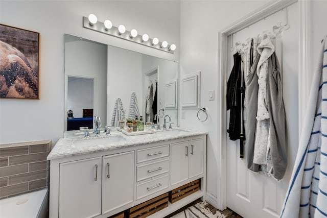 bathroom with a bathing tub and dual bowl vanity