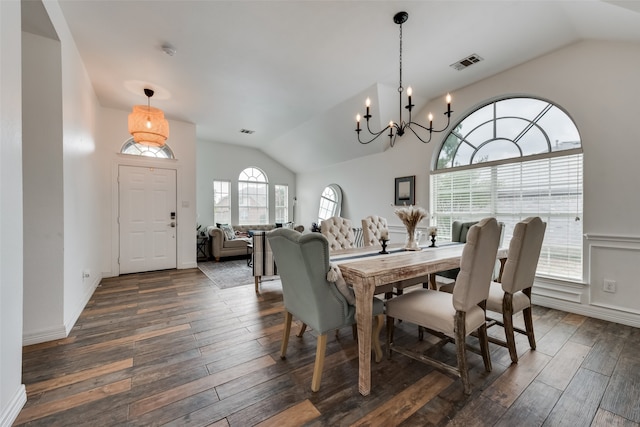 dining space with dark wood-type flooring, a notable chandelier, and vaulted ceiling