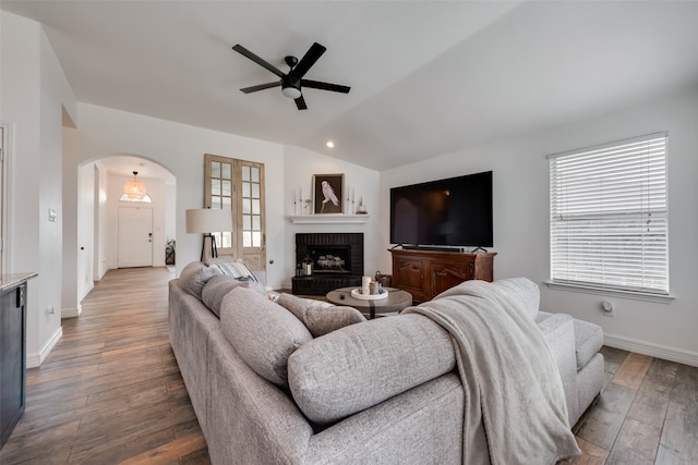 living room with a brick fireplace, hardwood / wood-style floors, and plenty of natural light