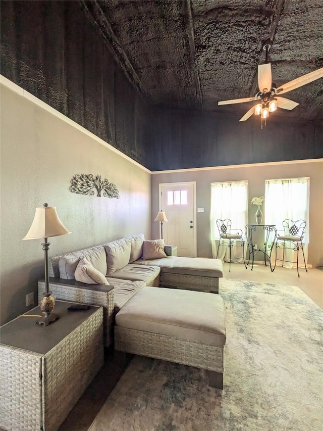 living room with ceiling fan, a towering ceiling, and a wealth of natural light