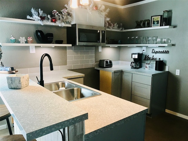 kitchen with tasteful backsplash, sink, and a kitchen bar