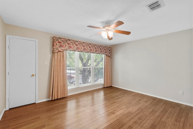 spare room with light wood-type flooring and ceiling fan