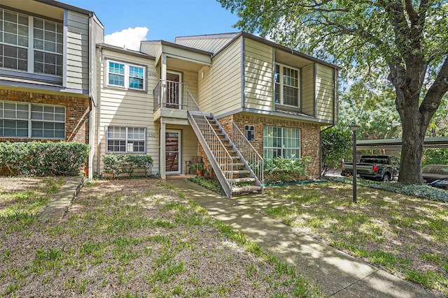 multi unit property featuring stairway and brick siding