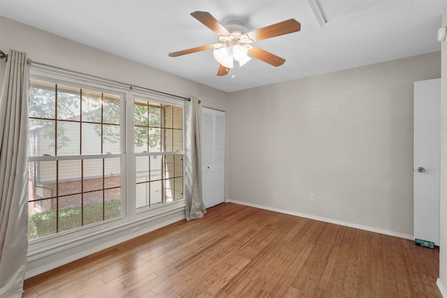 unfurnished room featuring ceiling fan, light hardwood / wood-style flooring, and a healthy amount of sunlight