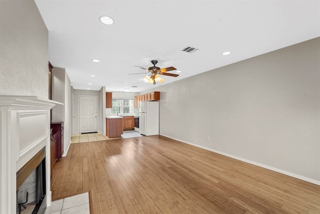 unfurnished living room featuring light tile patterned floors and ceiling fan