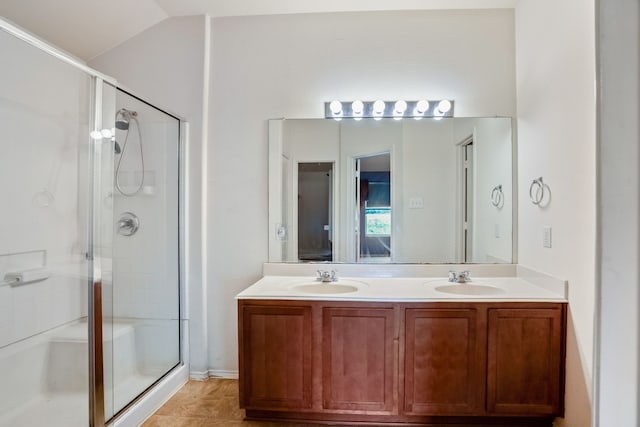 bathroom with tile patterned floors, walk in shower, vaulted ceiling, and double sink vanity