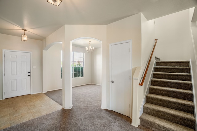 entrance foyer with a notable chandelier and light colored carpet