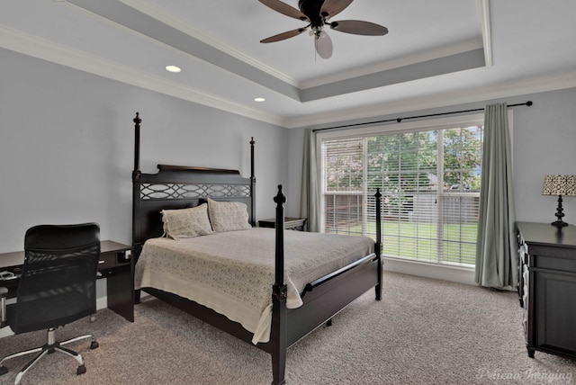 carpeted bedroom with ceiling fan, ornamental molding, and a tray ceiling