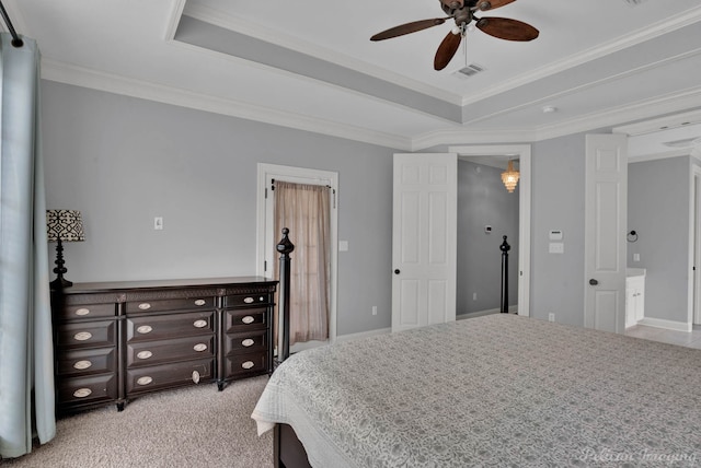 carpeted bedroom featuring a raised ceiling, ensuite bath, ceiling fan, and crown molding