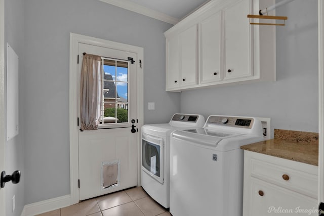 laundry room with cabinets, washer and dryer, ornamental molding, and light tile patterned flooring