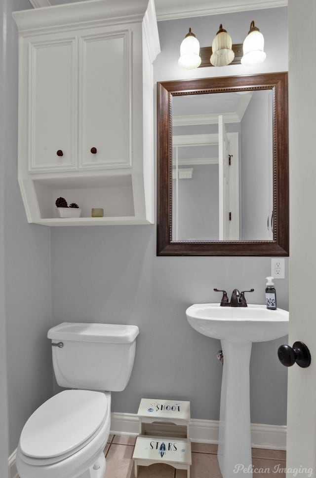 bathroom featuring tile patterned floors, ornamental molding, and toilet