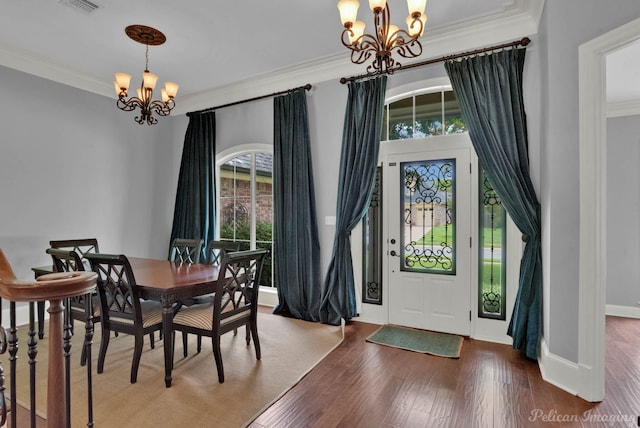 dining room featuring crown molding, hardwood / wood-style floors, and an inviting chandelier