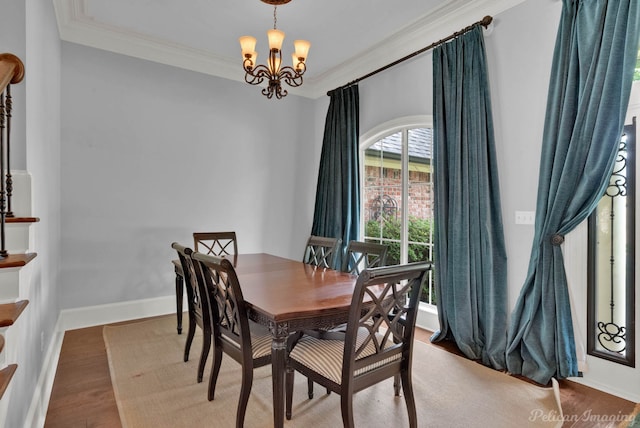 dining area featuring wood-type flooring, crown molding, and a chandelier