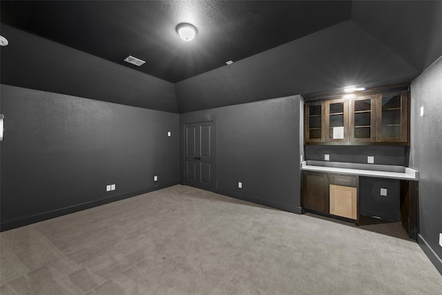 carpeted home theater featuring lofted ceiling and a textured ceiling