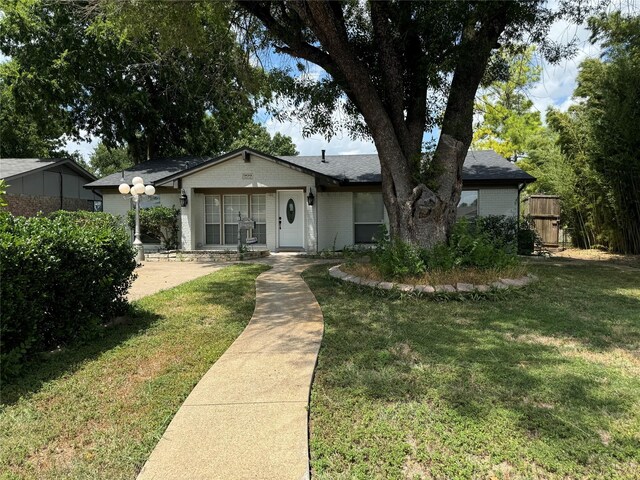 view of front of house with brick siding, fence, and a front yard