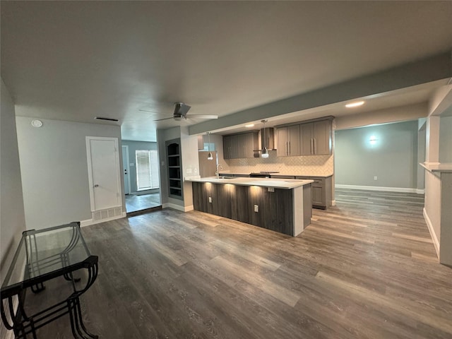 kitchen with wood finished floors, baseboards, light countertops, gray cabinets, and a sink