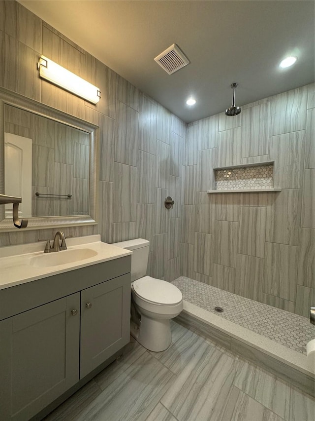 bathroom featuring visible vents, vanity, marble finish floor, toilet, and walk in shower