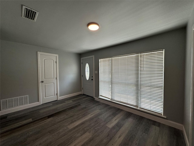 foyer entrance featuring baseboards, visible vents, and dark wood-type flooring